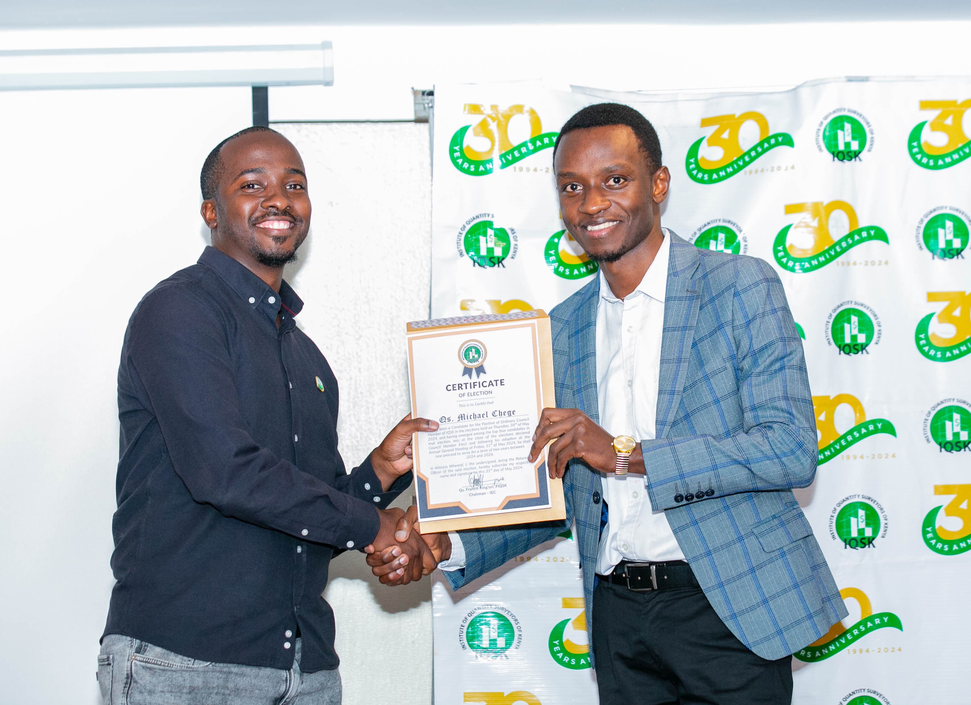 Qs. Michael Chege receives his Certificate of Election from Commissioner Grad. Qs. Ernest Nyakundi